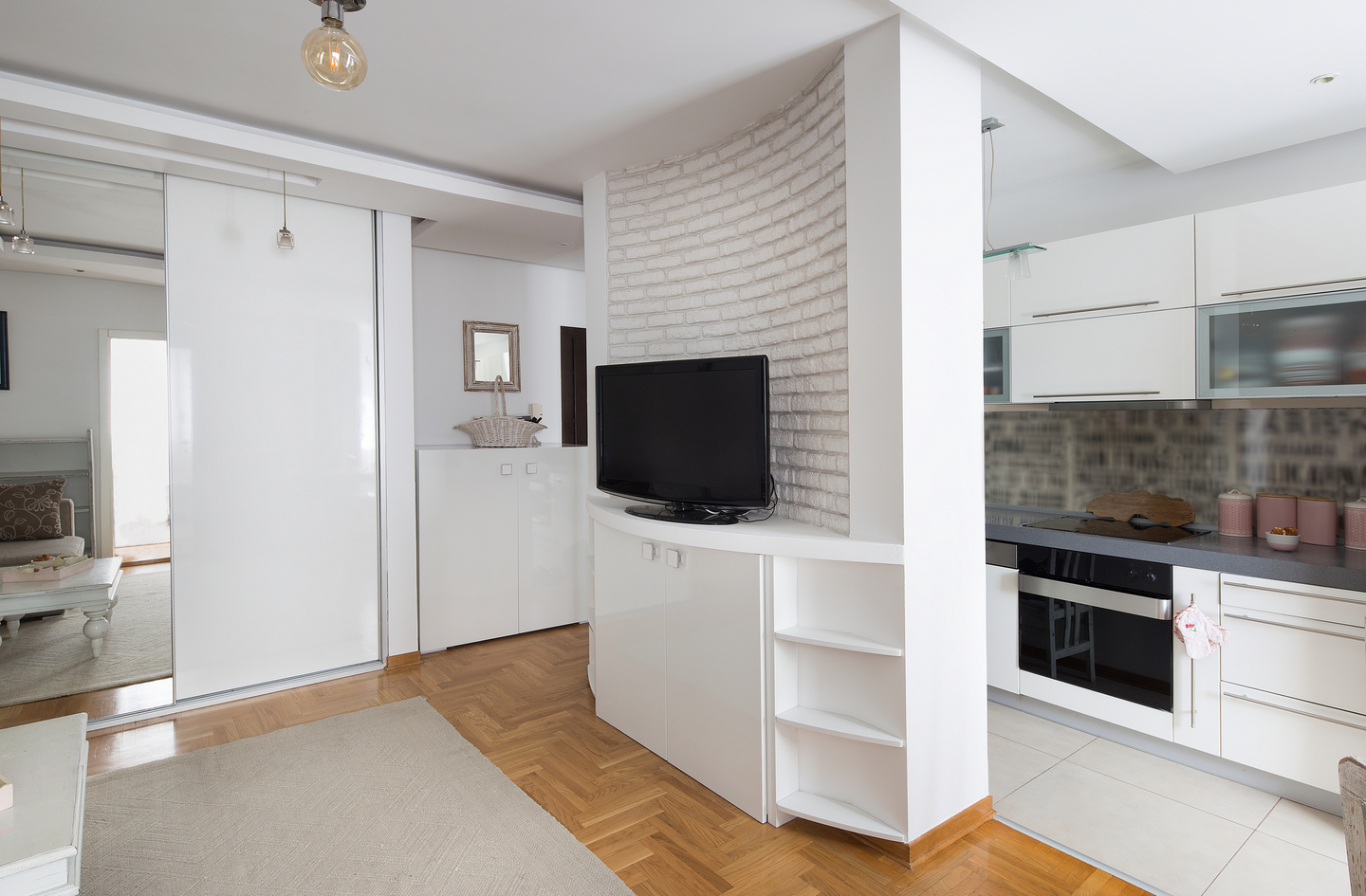 Small closet storage in a modern apartment with white mirrored sliding closet doors showing compact built-in storage solutions